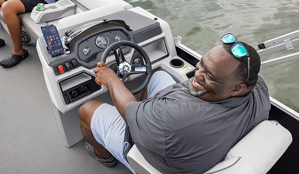 man sitting at the helm on a godfrey xperience pontoon