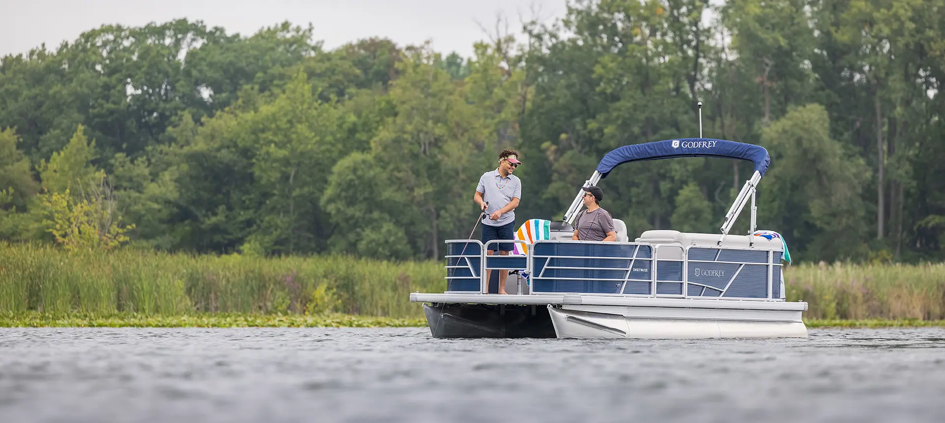 2 men fishing off the bow of a godfrey xperience fishing pontoon