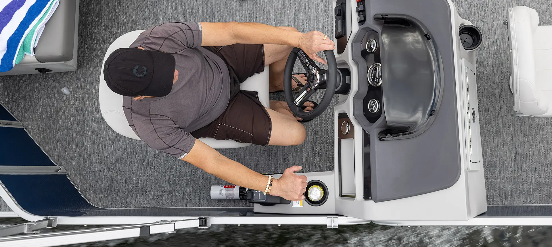 aerial view of a man sitting in at the steering console on a godfrey xperience fishing pontoon