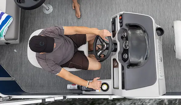 aerial view of a man sitting in at the steering console on a godfrey xperience fishing pontoon