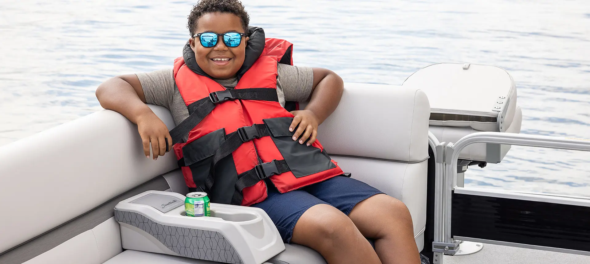 a boy smiling and relaxing on a godfrey xperience fishing pontoon