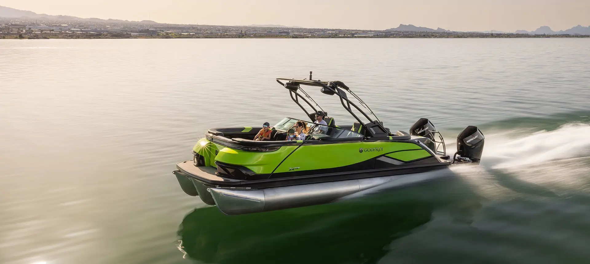 famille sur un ponton godfrey xp traversant un lac à toute vitesse