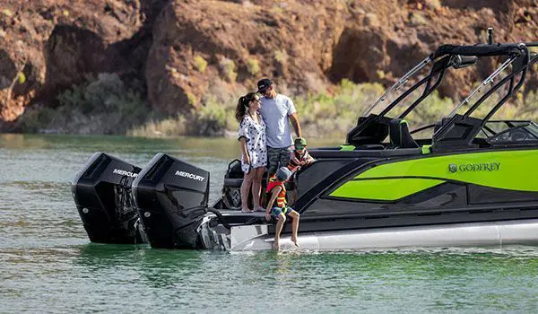 famille de 4 personnes près des deux moteurs à la poupe d’un ponton godfrey xp