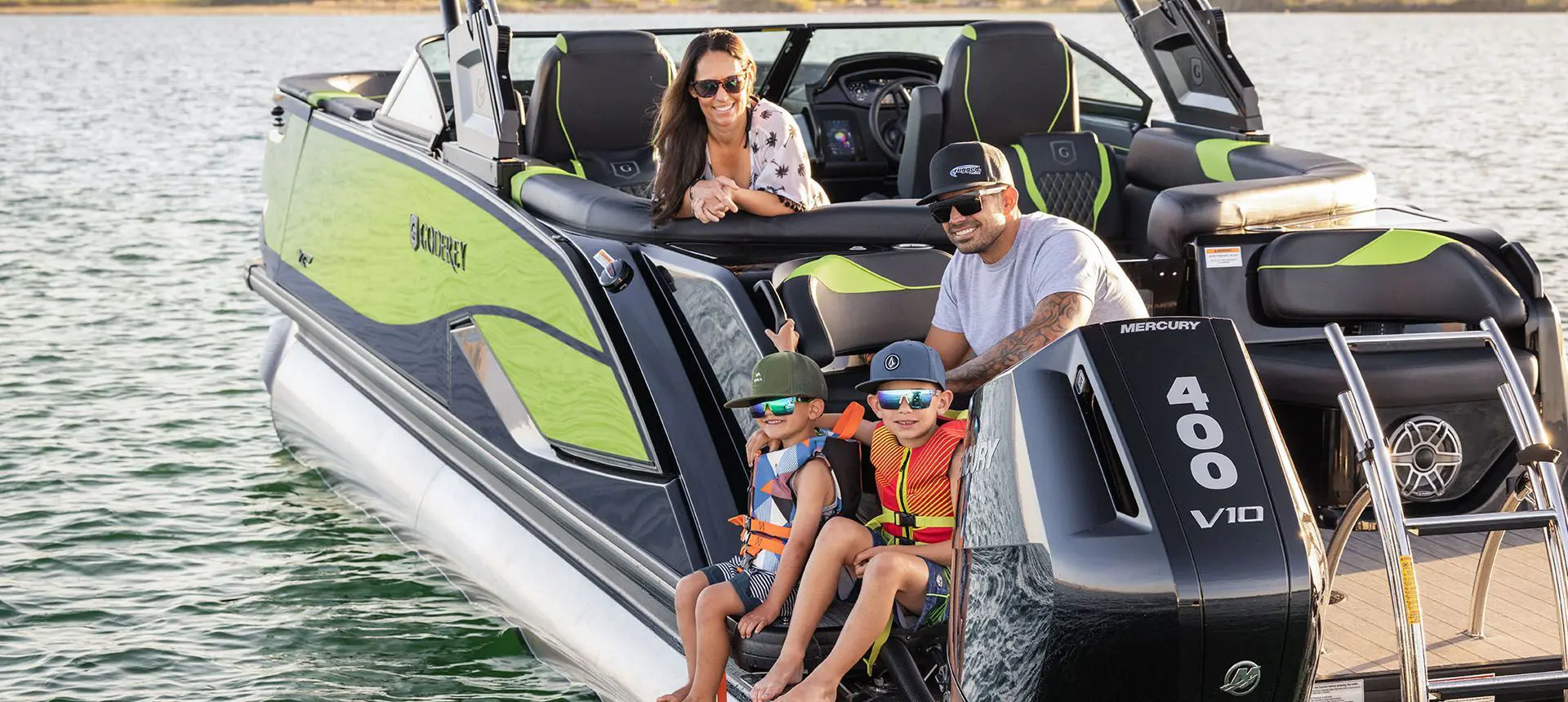 Family on the stern seating of a Godfrey XP Tritoon boat.