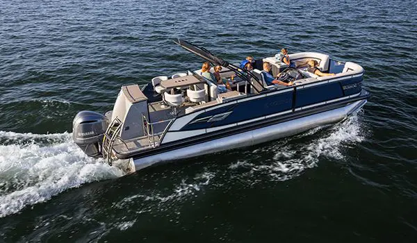 Side view of a family cruising across a lake on a godfrey aquapatio entertainment pontoon