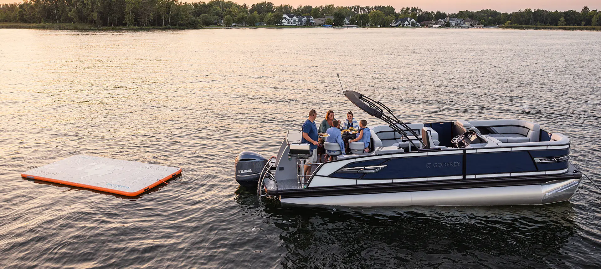 family sitting at the stern table on a godfrey aquapatio series pontoon