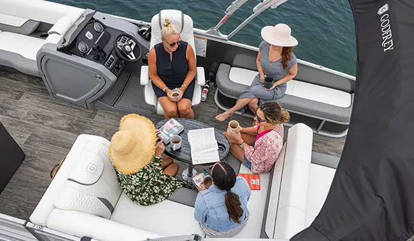 group of women chatting on a godfrey monaco lounge pontoon on a lake