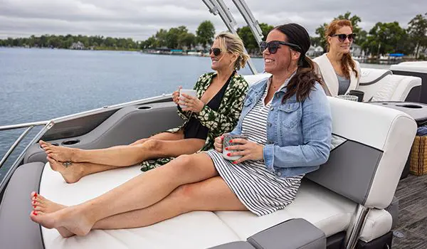 2 women sitting on the swingback seat on a godfrey monaco lounge pontoon