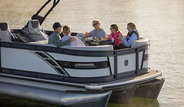 5 people having a snack at the bow table on a godfrey sanpan lounge pontoon