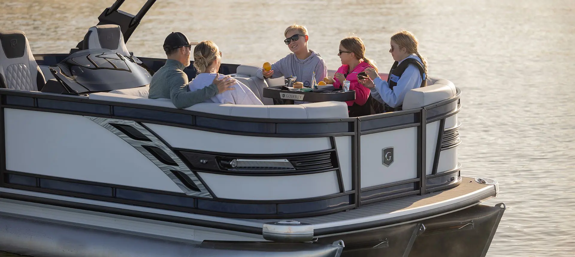 Ponton Godfrey Sanpan Windshield flottant sur un lac.