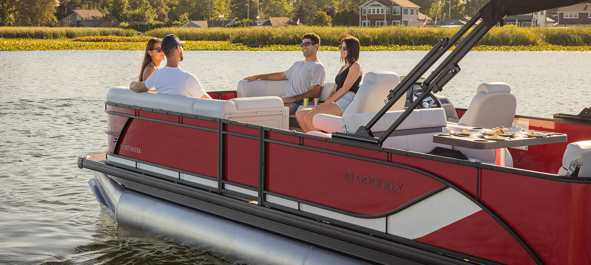 2 couples relaixing on the bow split bench seating on a godfrey sweetwater entertainment pontoon