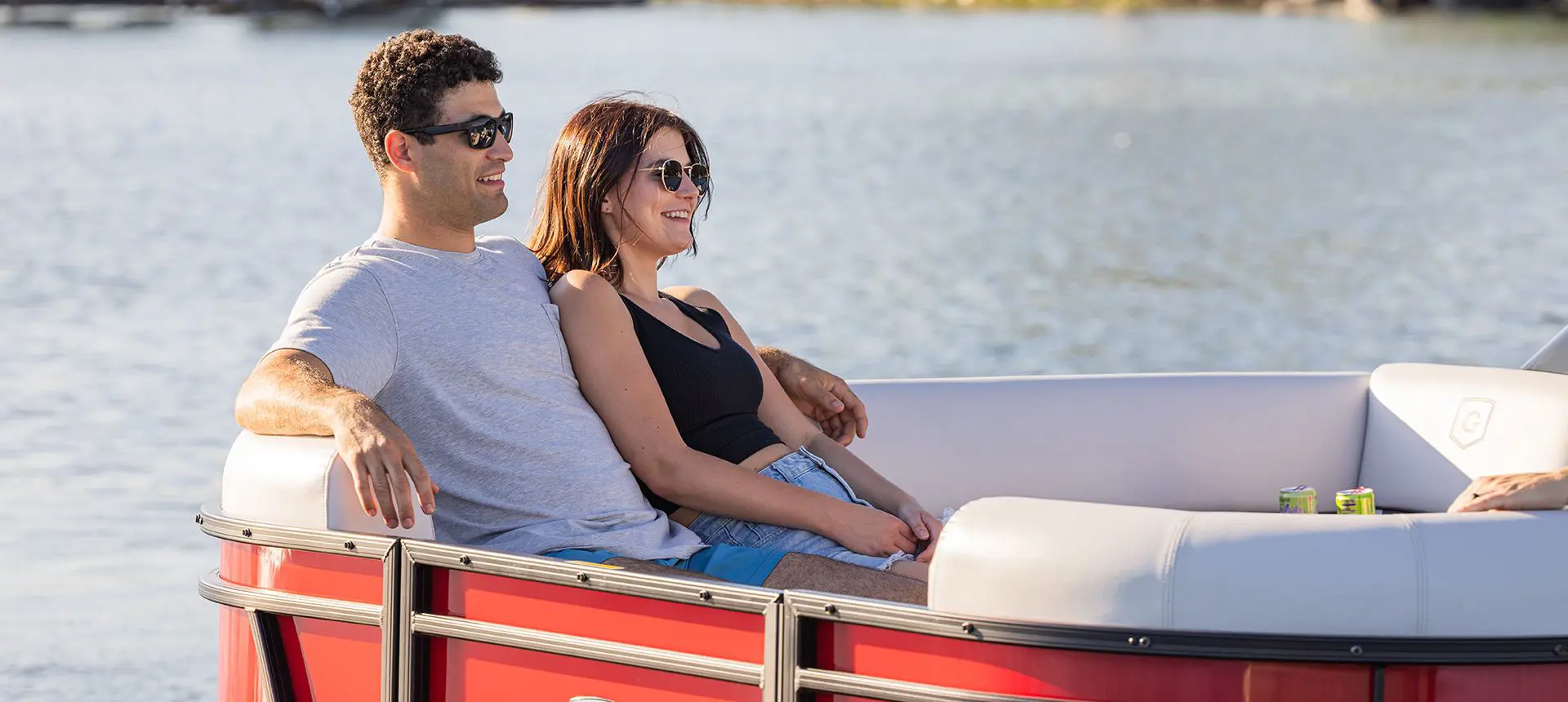 couple relaxing on the bow split bench seats on a godfrey sweetwater entertainment pontoon