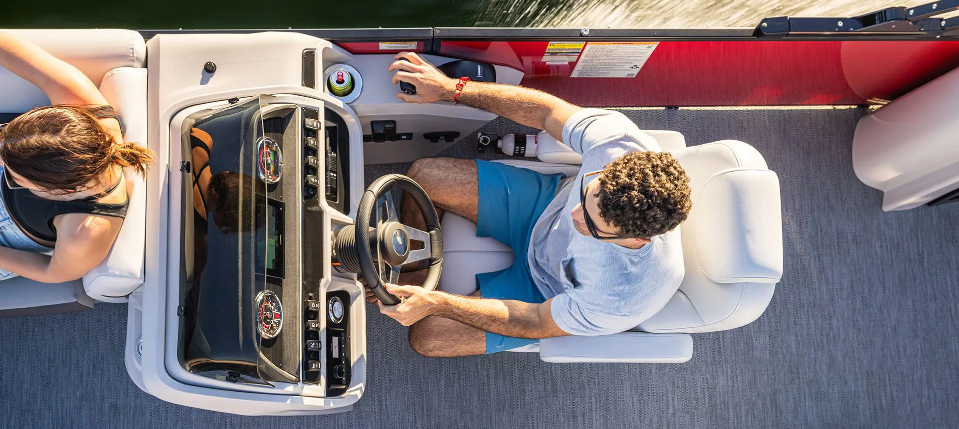 aerial view of a man at the steering console on a godfrey sweetwater entertainment pontoon