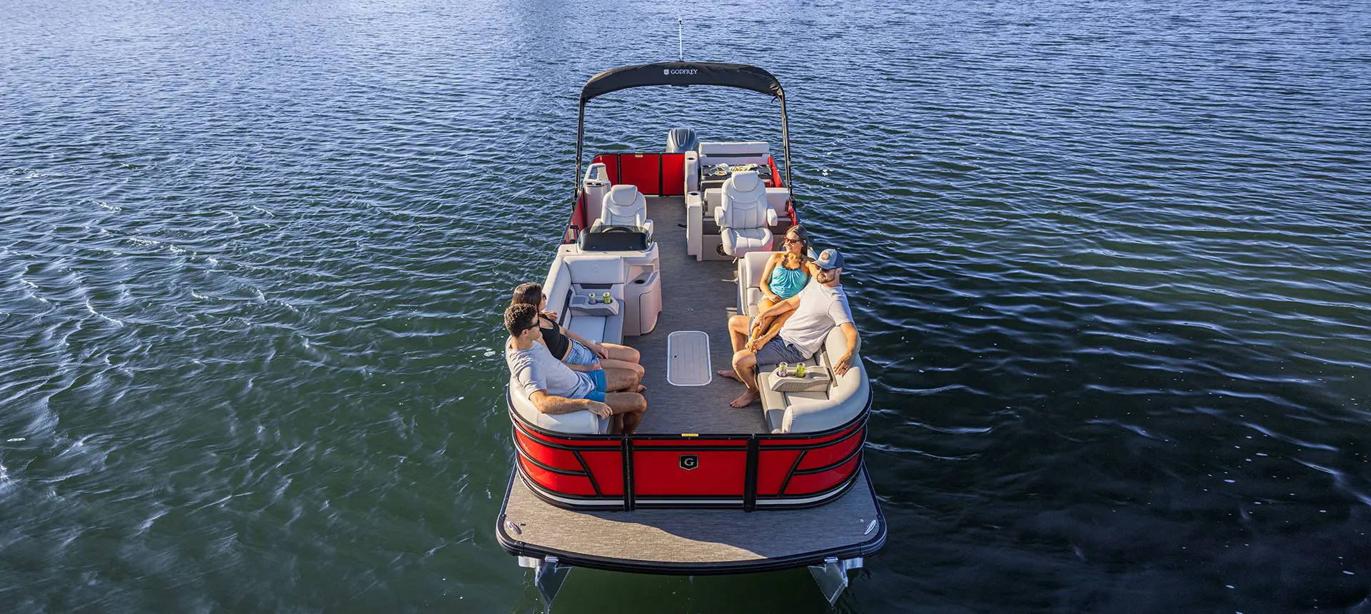 aerial view of 4 people sitting on the bow of a godfrey sweetwater entertainment pontoon
