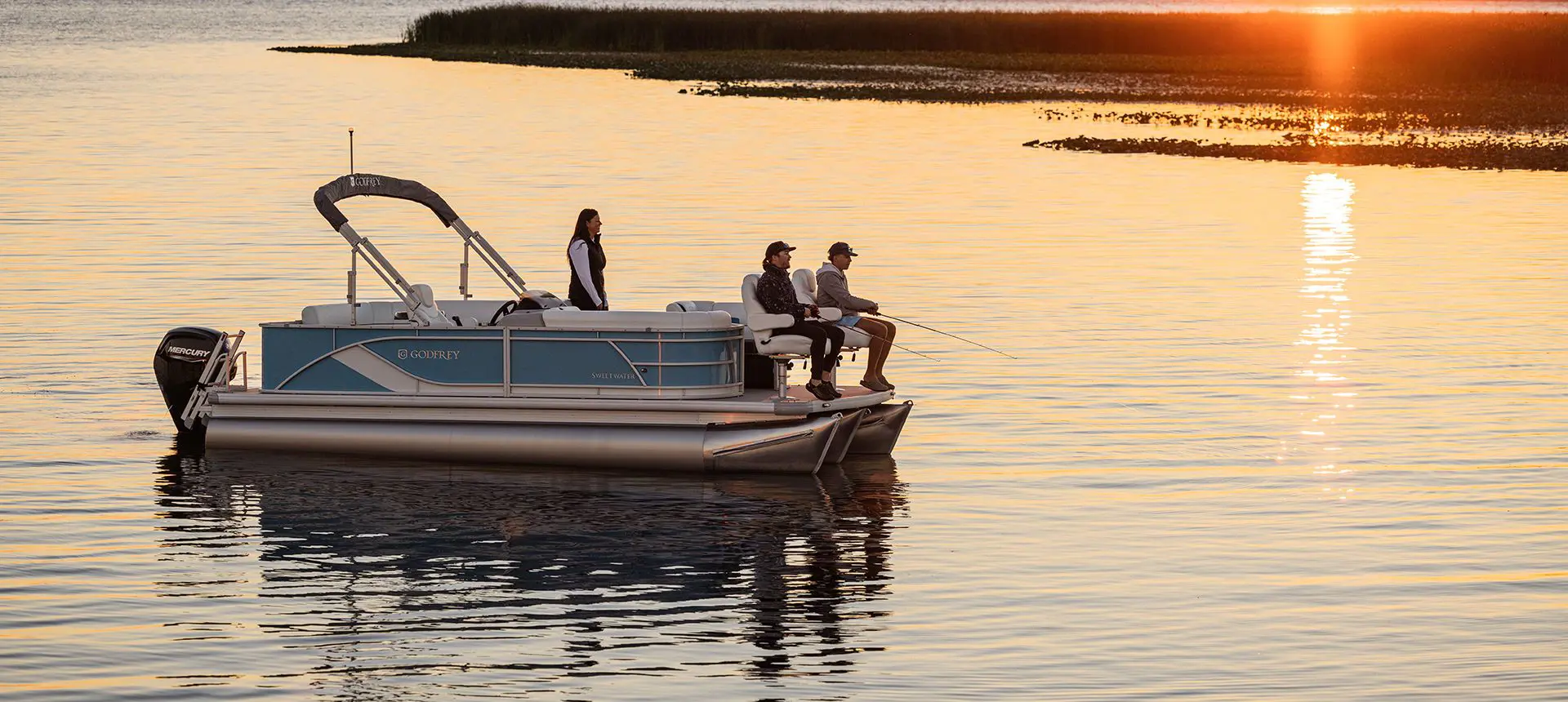 people fishing at dusk on a godfrey sweetwater fishing pontoon