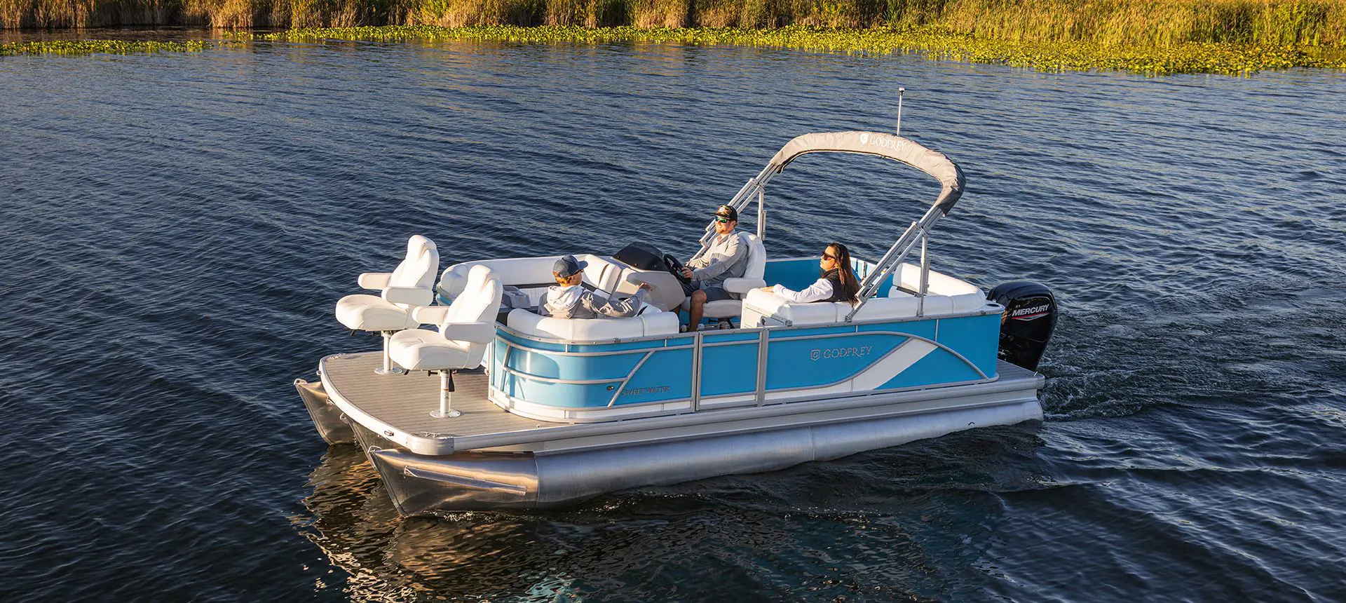 3 people on a godfrey sweetwater fishing pontoon cruising to their spot