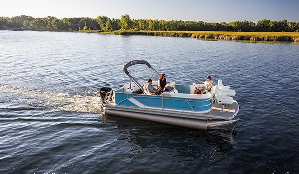 side view of a godfrey sweetwater fishing pontoon cruising across a lake
