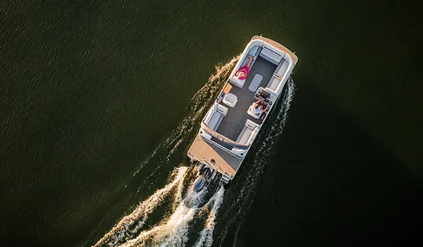 aerial view of a woman relaxing on the bow split bench seat on a godfrey sweetwater split bench pontoon