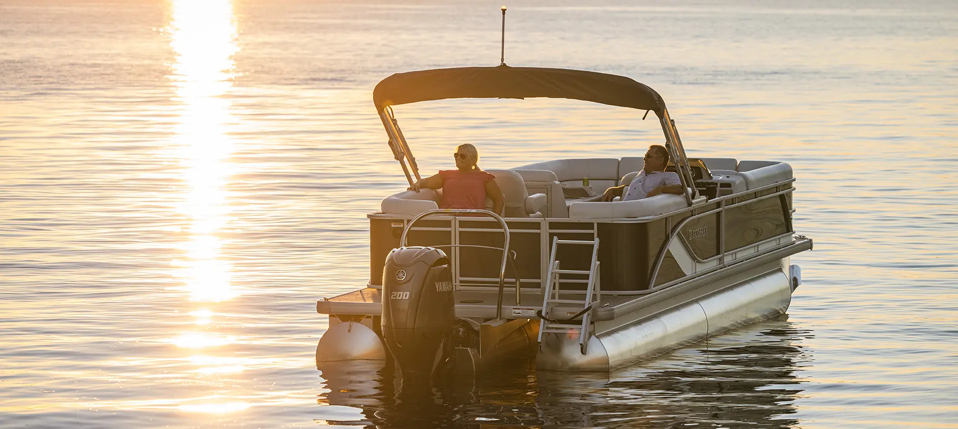 a couple relaxing on a godfrey sweetwater split bench pontoon