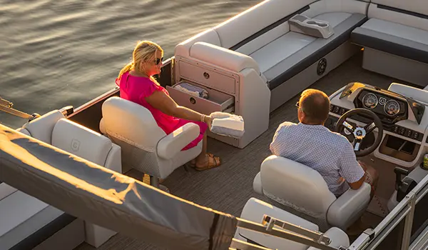 woman sitting in the co-captain's chair on a godfrey sweetwater split bench pontoon
