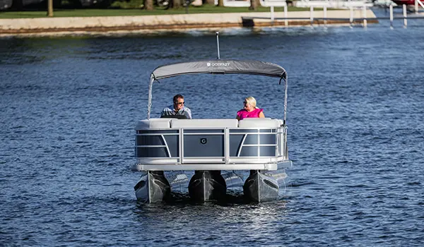 front view of a godfrey sweetwater split bench pontoon cruising on a lake