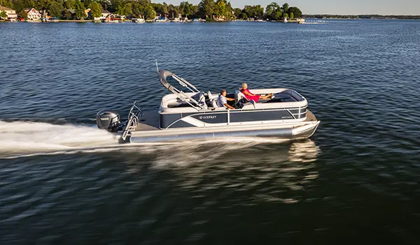 side view of a godfrey sweetwater split bench pontoon cruising across a lake