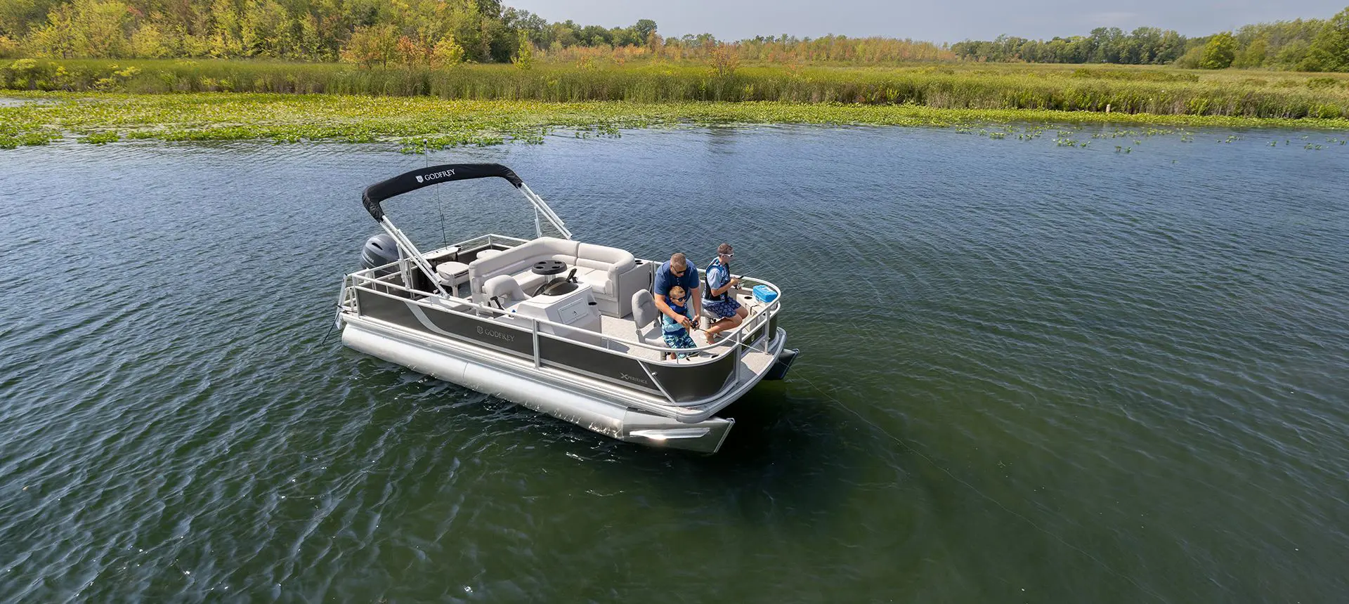 dad fishing with his sons off the bow of a godfrey xperience fishing pontoon