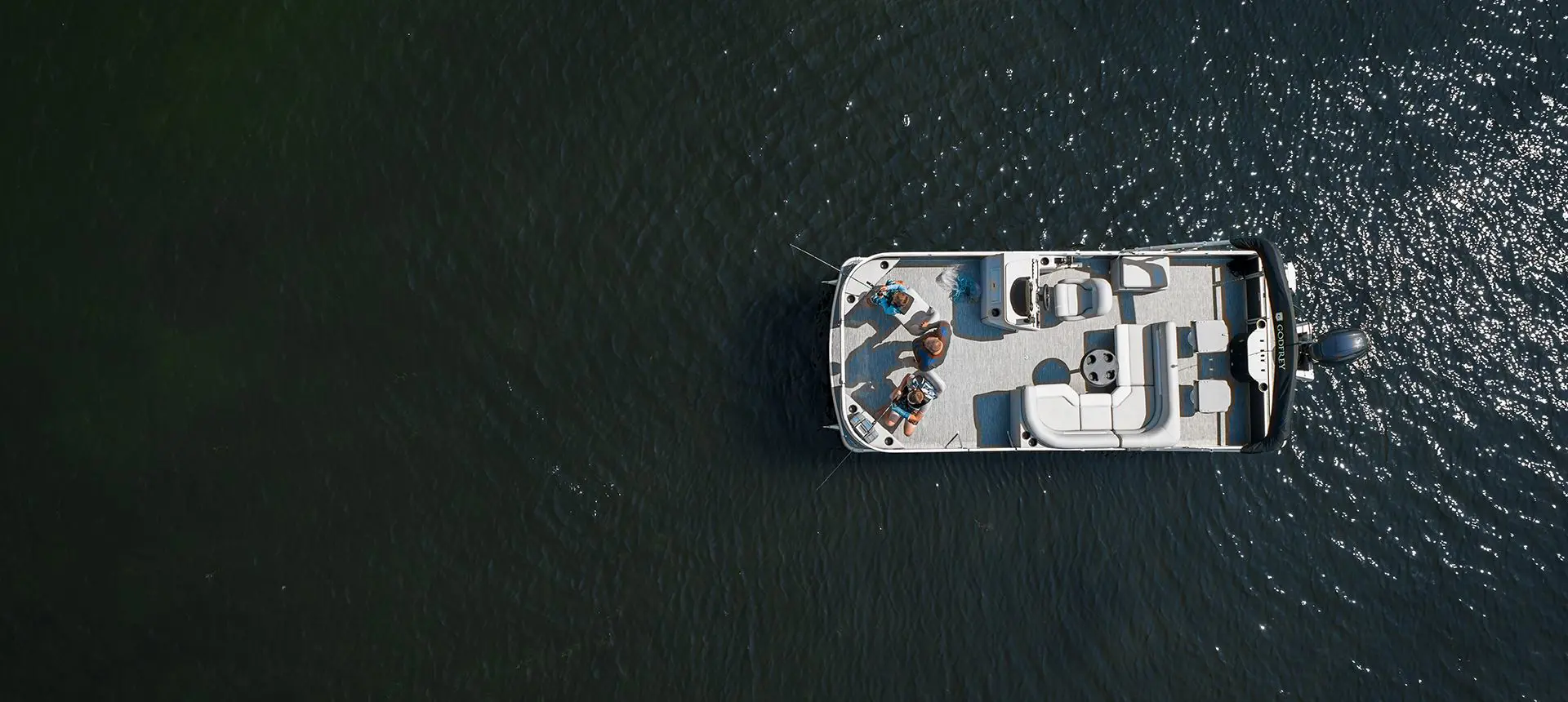 aerial view of a dad fishing with his sons off the bow of a godfrey xperience fishing pontoon