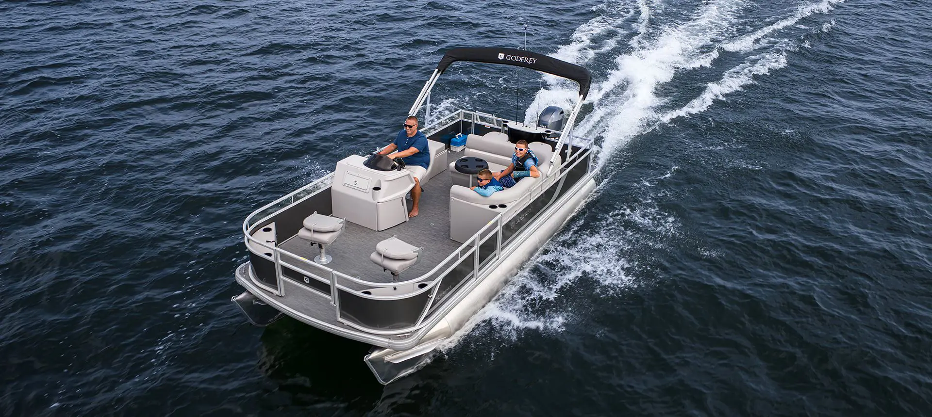 dad and sons cruising on a godfrey xperience fishing pontoon