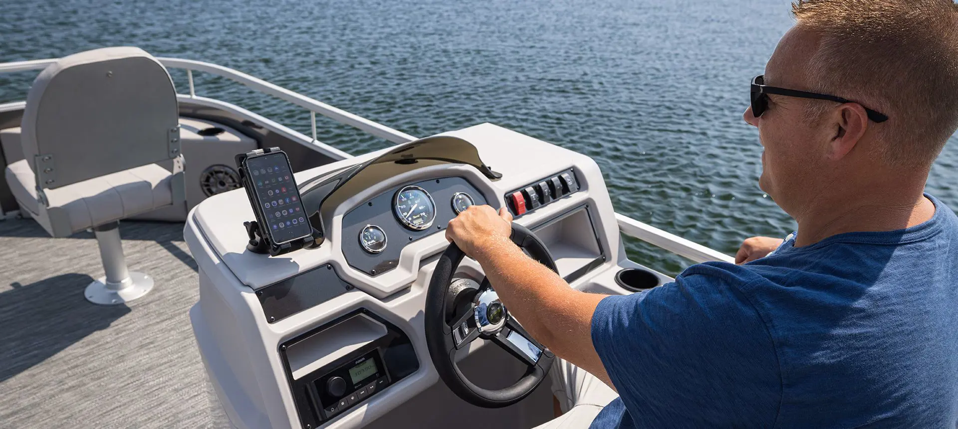 man sitting at the helm on a godfrey xperience fishing pontoon