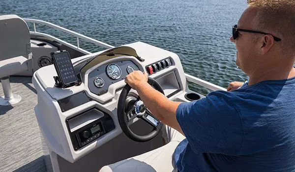 man sitting at the helm on a godfrey xperience fishing pontoon