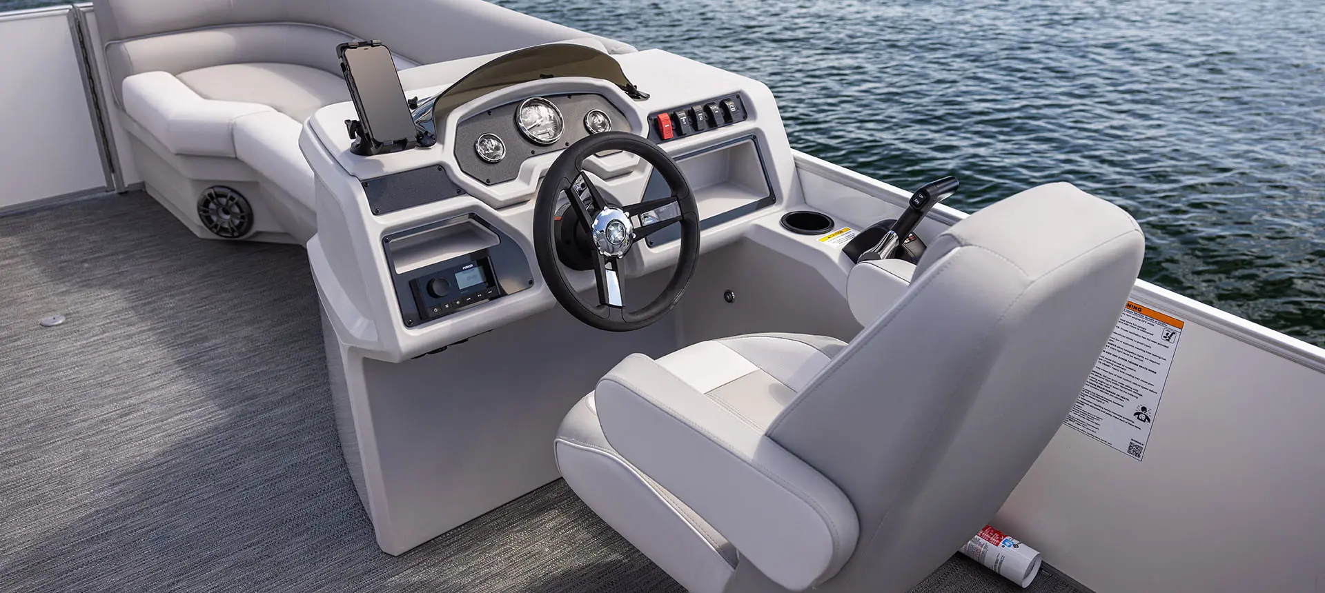 captain's chair and steering console on a godfrey xperience split bench pontoon