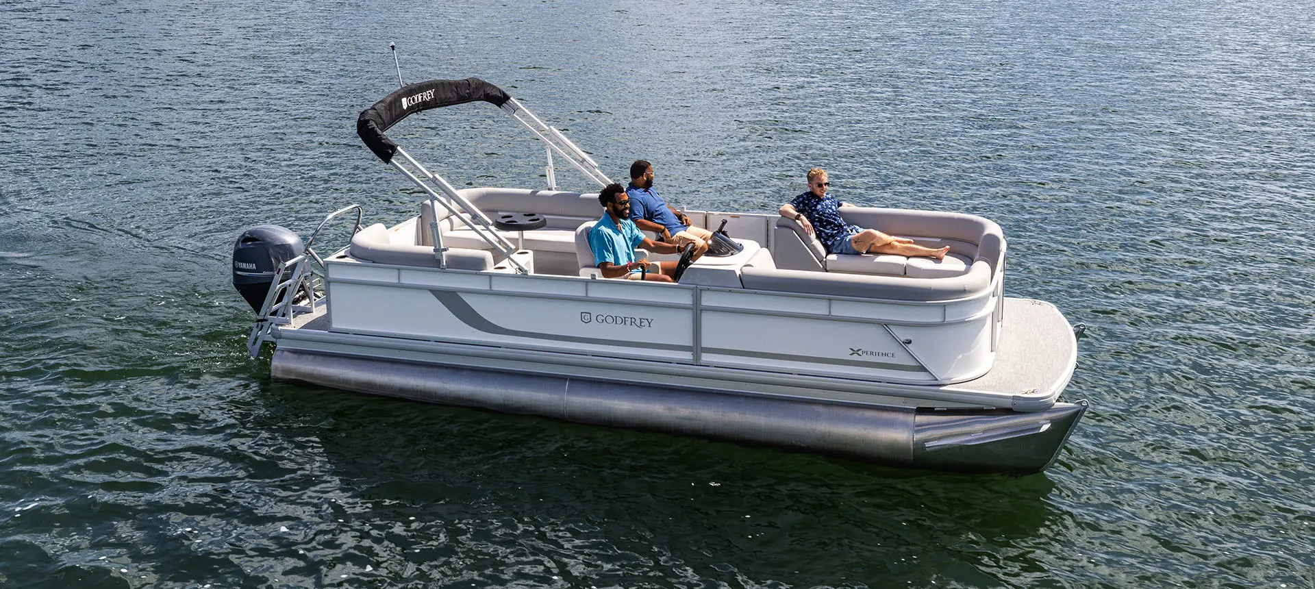 side view of a godfrey xperience split bench pontoon floating on a lake