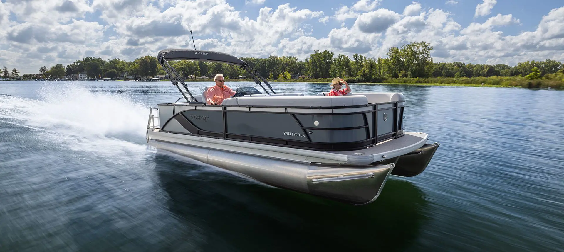 2 women relaxing on a the bow of a godfrey sweetwater pontoon