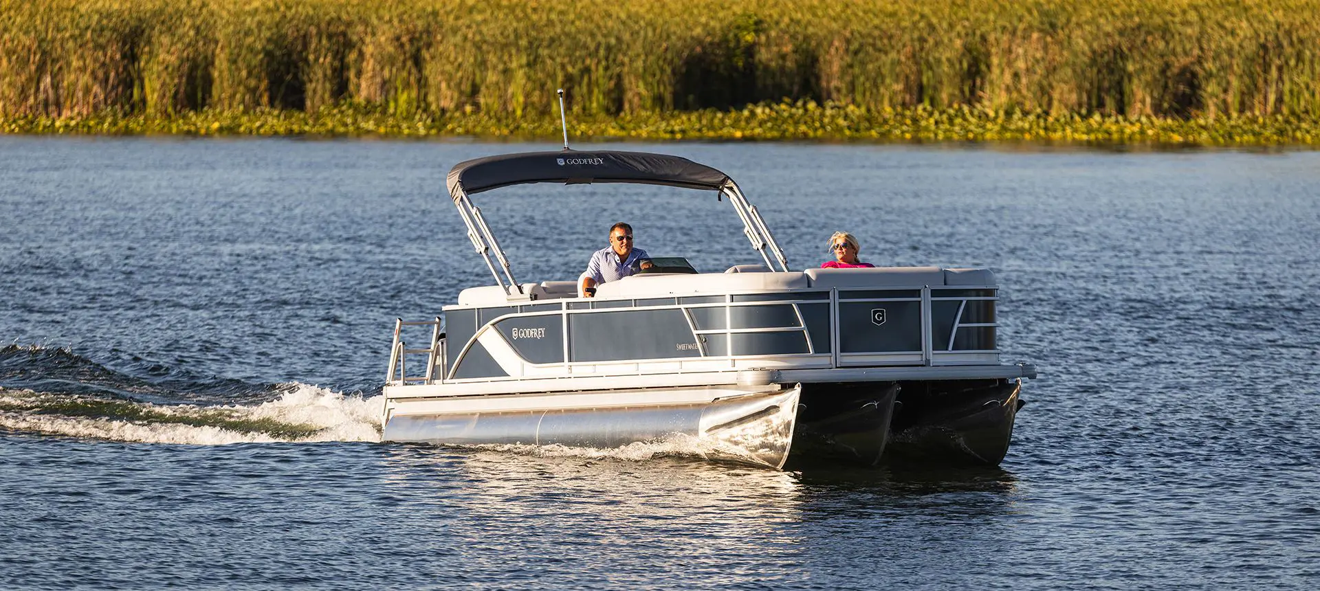 couple relaxing on a docked godfrey sweetwater pontoon