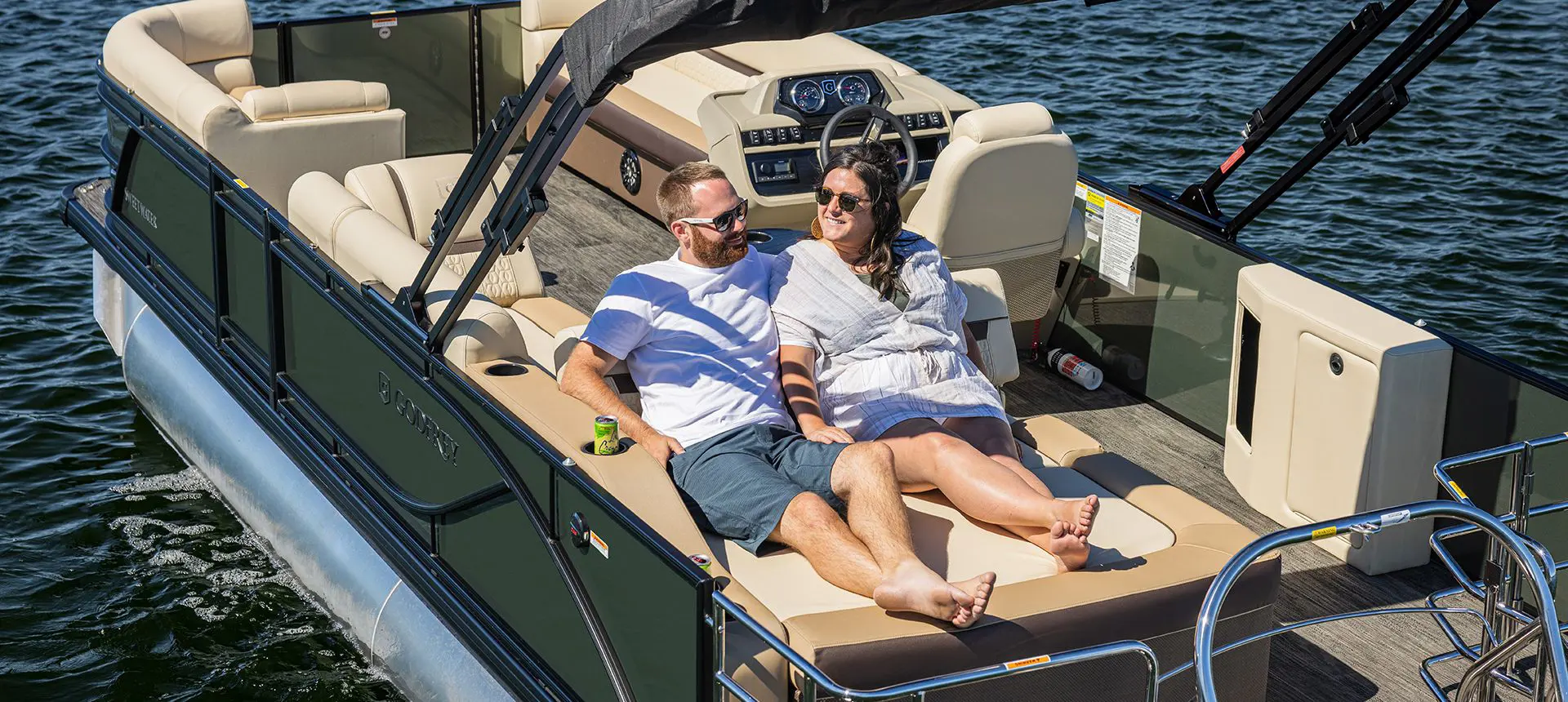 2 women relaxing on a the bow of a godfrey sweetwater pontoon
