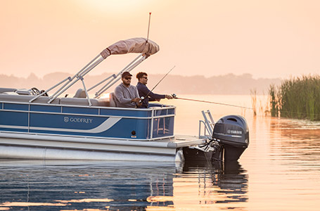 2 men sitting on the stern fish seats and fishing off of a Godfrey pontoon boat with the Fishing layout.