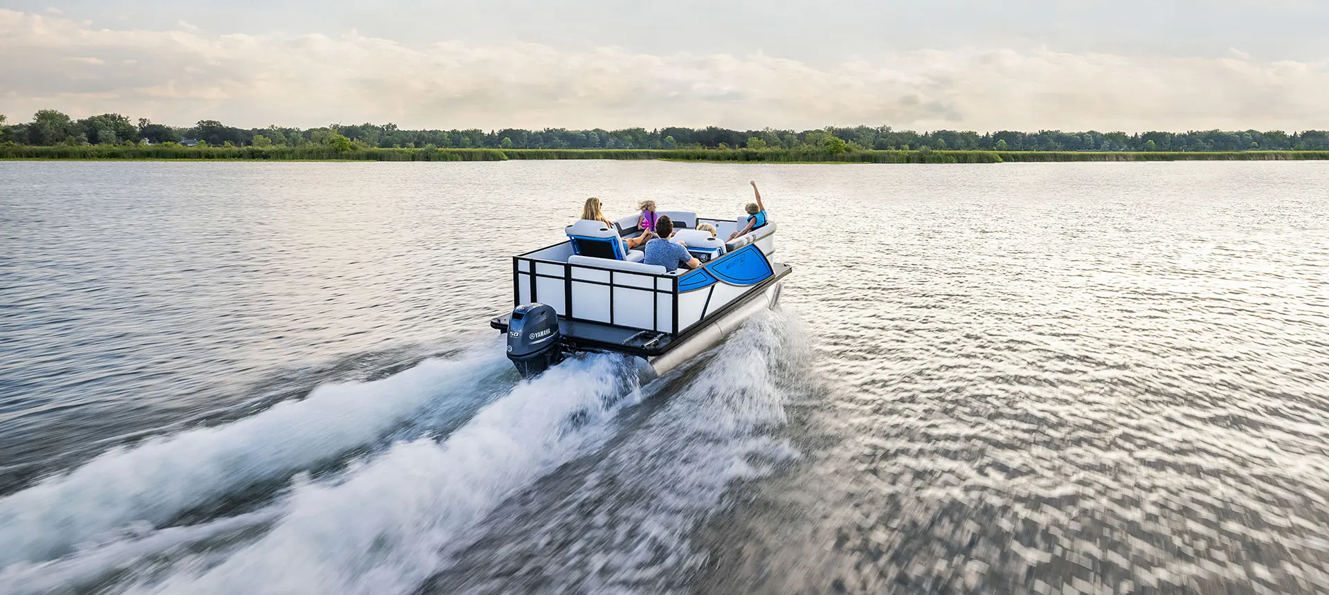 Family on a Godfrey Mighty G Cruise pontoon boat cruising the lake.