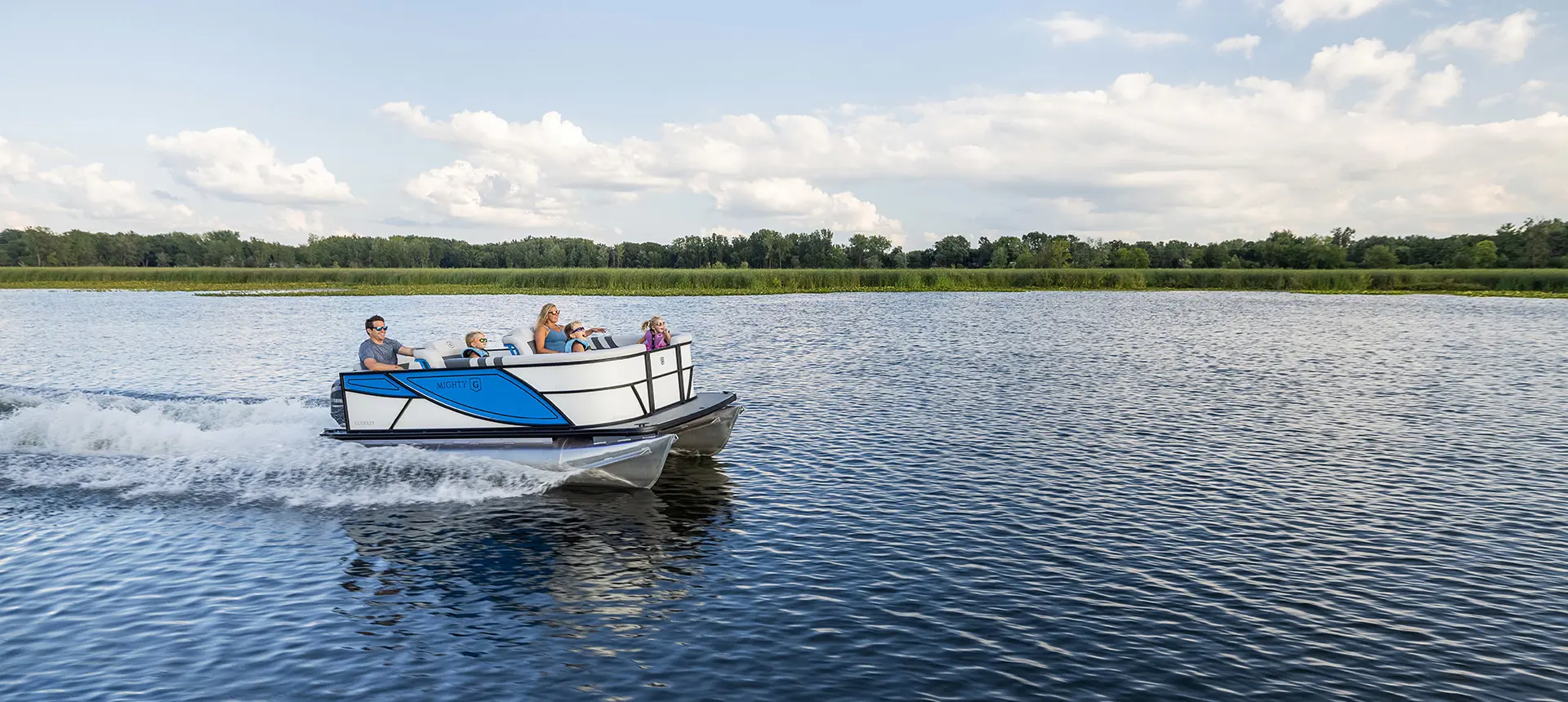 Family cruising the lake on a Godfrey Mighty G Cruise pontoon boat.