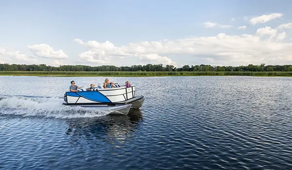 Family cruising the lake on a Godfrey Mighty G Cruise pontoon boat.