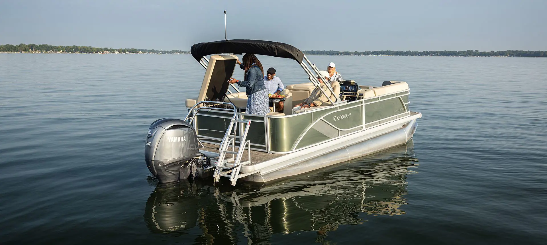 Woman looking into the stern storage area behind the seat on a Godfrey Sweetwater Cruise pontoon boat.