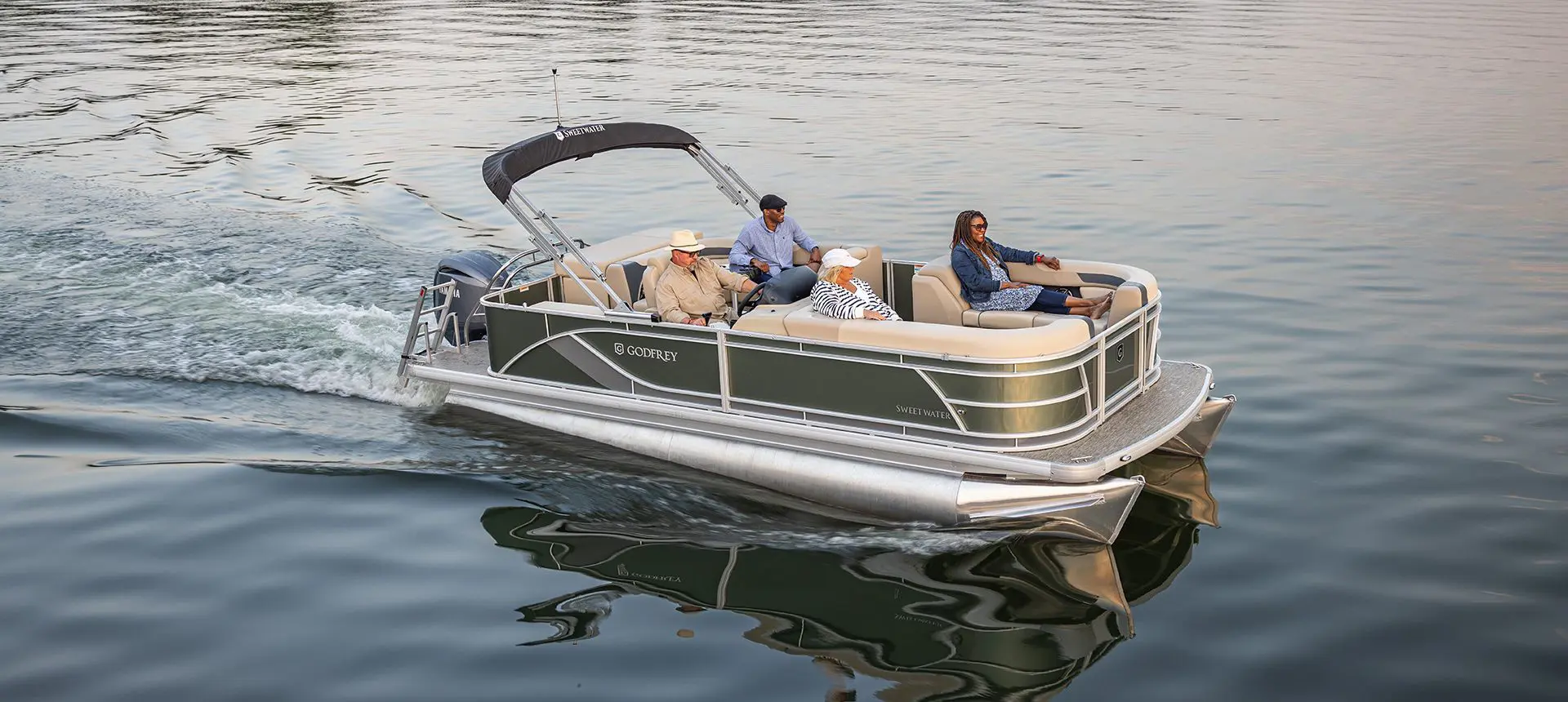 Aerial view of 4 people on board a Godfrey Sweetwater Cruise pontoon boat cruising the lake.