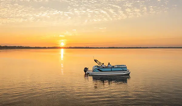 Aerial view of 4 people cruising the lake on a Godfrey Sweetwater Entertainment pontoon boat.