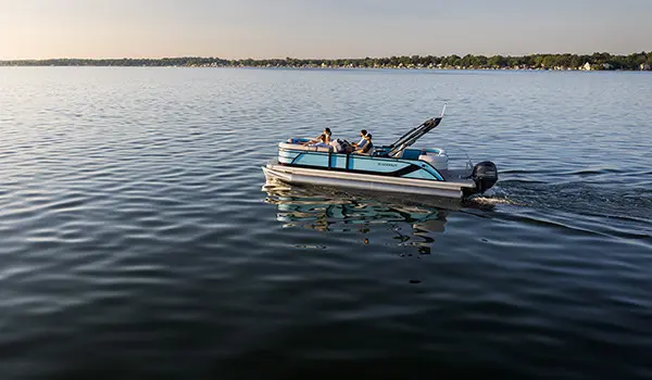 Aerial view of a woman relaxing on the bow split bench seat on a Godfrey Sweetwater Entertainment pontoon boat.