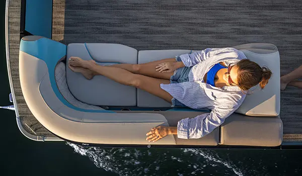 4 people relaxing while cruising the lake on a Godfrey Sweetwater Entertainment pontoon boat.