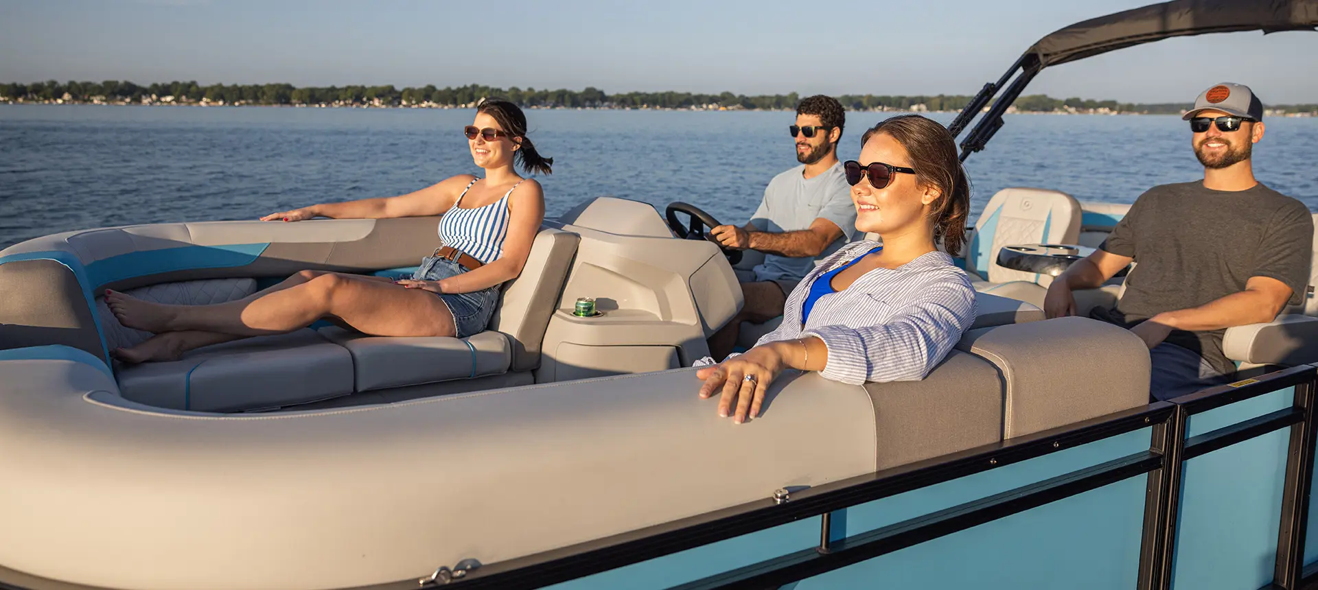 A woman smiling at a man at the helm of a Godfrey Sweetwater Entertainment pontoon boat.
