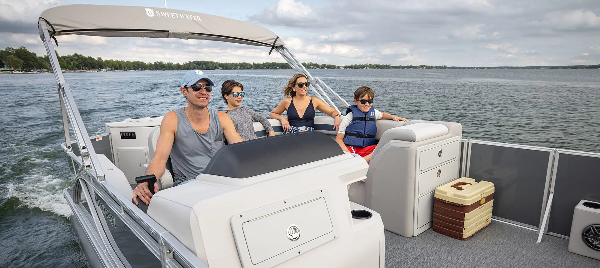 Family cruising to a fishing spot on a Godfrey Sweetwater Fishing pontoon boat.