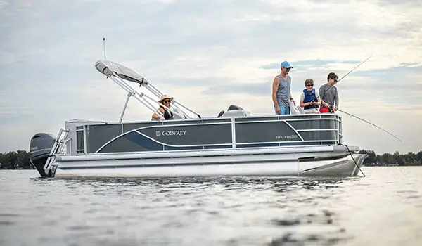 2 boys fishing off the bow of a Godfrey Sweetwater Fishing pontoon boat while their parents watch.