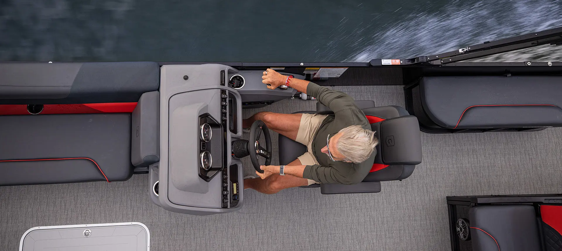 Overhead view of a man at the helm of a Godfrey Sweetwater Lounge pontoon boat.