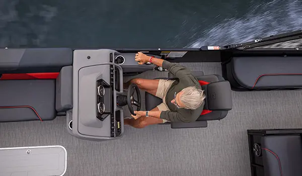 Overhead view of a man at the helm of a Godfrey Sweetwater Lounge pontoon boat.